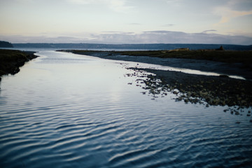 Fototapeta na wymiar Blue rippling water on coast at sunset