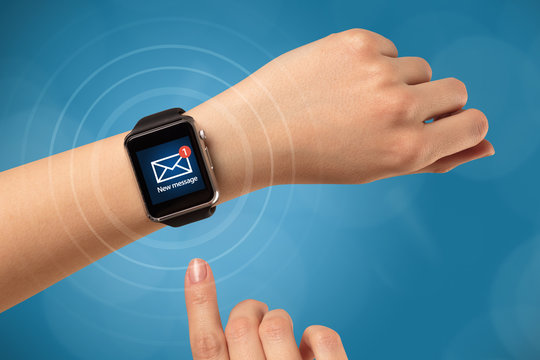 Hand with smartwatch and blue background