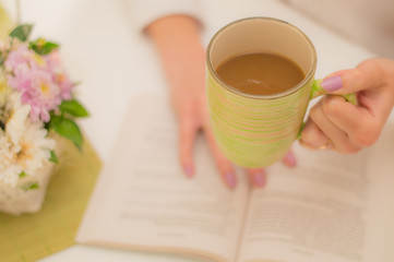 girl enjoying coffee and reading a book