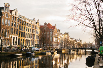 Obraz premium View of traditional houses in Amsterdam Netherlands Europe. Sunset. Evening. European style houses. Channels
