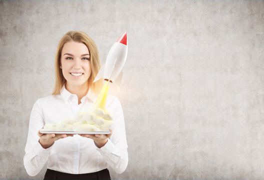 Woman with tablet and small rocket