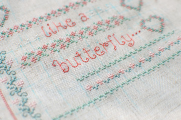 Cross-stitch embroidery on linen. Sampler with floral patterns.