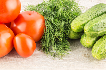 Cucumber, tomato, pepper and fennel on a white wooden background close up.