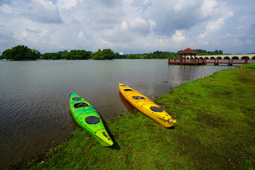 Scenery of Putrajaya Wetland Recreation Centre with Colorful Canoes Rests on a Shore. 