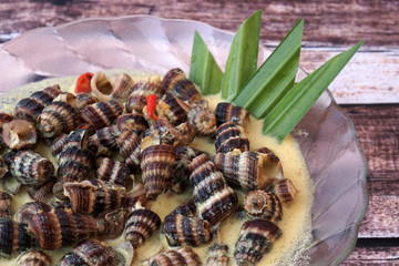 Siput Masak Lemak - Traditional Malay Cuisine. snails cook with turmeric herbs, coconut milk, spices and chilli