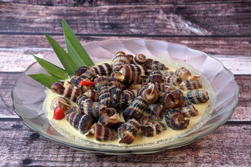Siput Masak Lemak - Traditional Malay Cuisine. snails cook with turmeric herbs, coconut milk, spices and chilli
