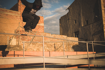 Chico joven saltando en la azotea al atardecer