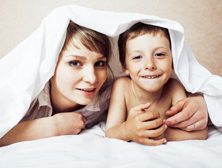 young blond woman with little boy in bed, mother and son, happy 