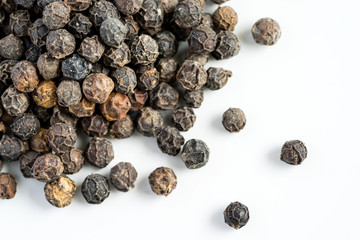 Black pepper seeds on a white background with some blurry effects (bokeh) applied. Organic seeds origin from Sarawak of Borneo, Malaysia.