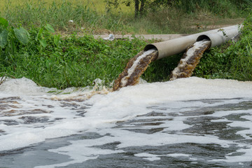 Powerful water flowing from a large pipe using a water pump for agricultural use in paddy fields.