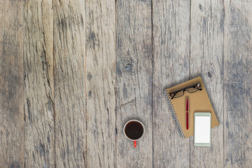 A cup of coffee, book,pen and eyeglasses on wood table,top view.