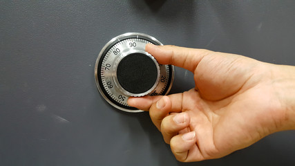  Close up of a safe lock and male hand conceptual image - obrazy, fototapety, plakaty