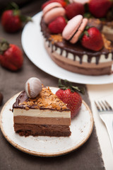 Three chocolate cake decorated with strawberries and macaroons