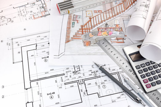graphical plans and hand drawn sketches of living room interior and drawing tools on designers table