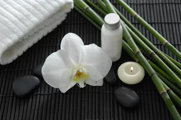 Rolgordijnen Spa setting with candle ,orchid ,towel ,stones ,grove on mat © Mee Ting