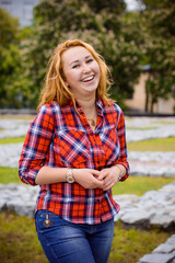 Obraz premium American funny girl in shirt and jeans in city park have a good mood smiling and rest