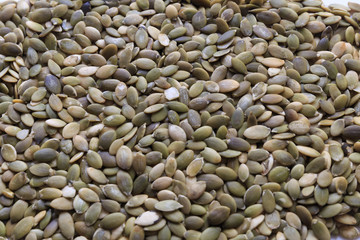 Vegan food. Raw pumpkin seeds for roasting on a white table
