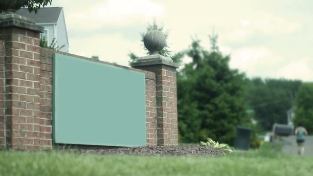 Generic entrance to modern development housing plan as woman jogs past - Color Graded