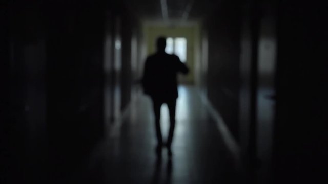 Silhouette of a man runs through the dark corridor. Dismissal.The Ghost of a businessman .The path to success.