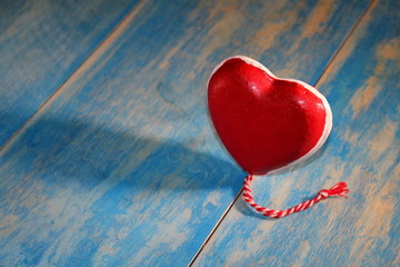 красивая фигурка красного сердце на синих деревянных досках          