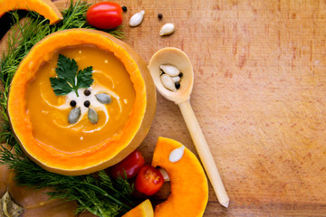 Traditional Cream soup in a pumpkin with lid Seeds spices dill and parsley