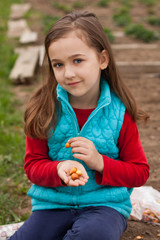 Cute Little Russian Seven Years Girl With Onion On Her Hand In Spring Garden. Preparing Onion-Seedling To Planting In Spring.