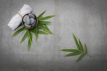 Fototapete Gray stones in bowl with bamboo leaf,towel gray background © Mee Ting
