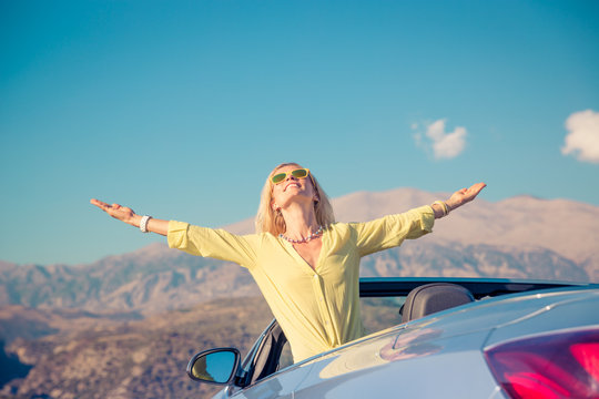 Happy woman travel by car in the mountains