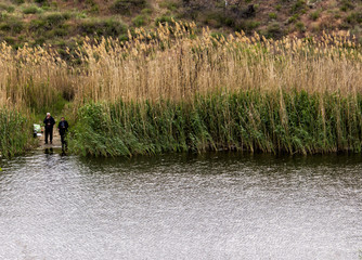 Obraz na płótnie Canvas in the distance fishermen catch fish