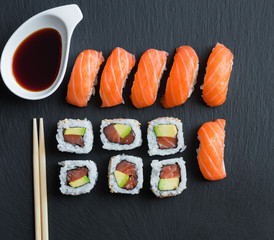 Salmon sushi and roll sushi on black