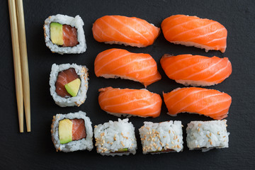 Salmon sushi and roll sushi on black