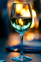 Green glass of water is on the table in a dark restaurant.