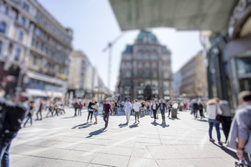 Crowd of anonymous people walking on busy city street