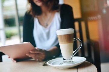 Asian woman using laptop and drinking coffee with copy space in coffee shop 