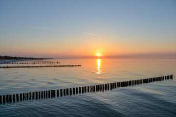 Naklejka na ściany i meble Sonnenuntergang am Meer Ostsee mit Buhnen