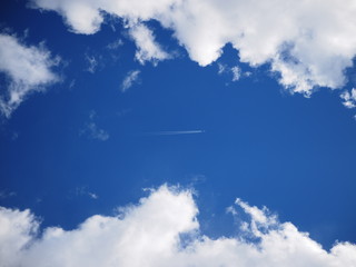 The plane flies in the sky between the clouds