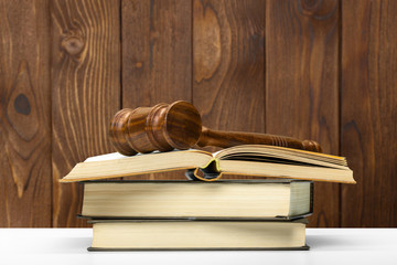 Wooden gavel and books on wooden table