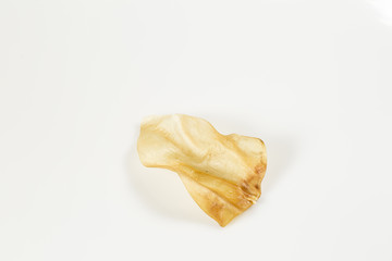 Chewing veal leather ear for dogs on white background, top view