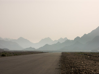 desert road leading to hazy mountains