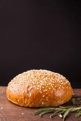 Close-up of burger bun with sesame seeds on black background