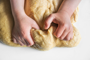 Little kid kneading dough. Children helping home, cooking.