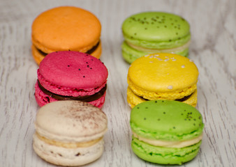 Multicolored macarons close-up on a light wooden table