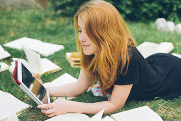 Woman learning with ebook reader and book. Choice between modern educational technology and traditional way method. Girl holding digital tablet pc and textbook. Contemporary education.