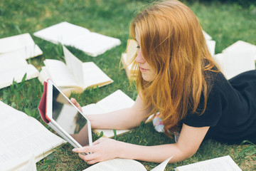 Woman learning with ebook reader and book. Choice between modern educational technology and traditional way method. Girl holding digital tablet pc and textbook. Contemporary education.