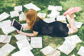 Woman learning with ebook reader and book. Choice between modern educational technology and traditional way method. Girl holding digital tablet pc and textbook. Contemporary education.