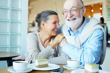 Cheerful and affectionate seniors spending time in cafe