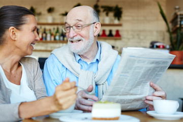 Fototapeta na wymiar Senior couple discussing latest news in cafe