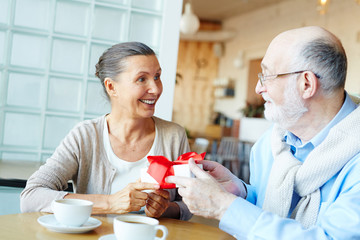 Happy female taking box with present from her husband