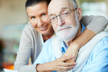 Devoted senior spouses looking at camera