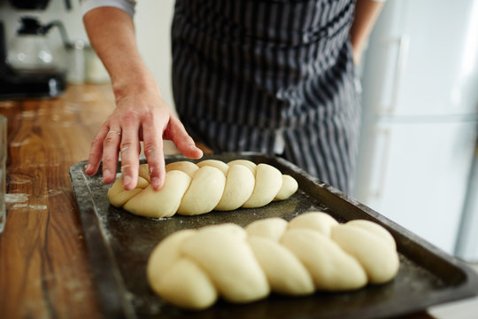 Pastry-chef making buns from dough
